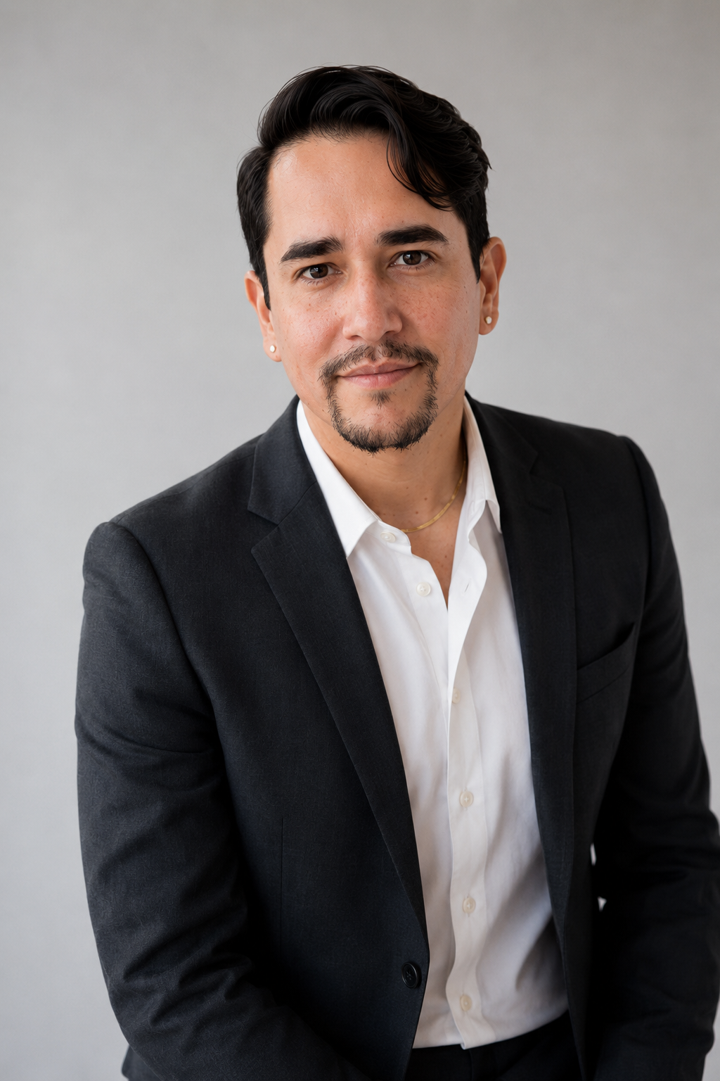 Christopher Collazo seated in a dark suit and white shirt